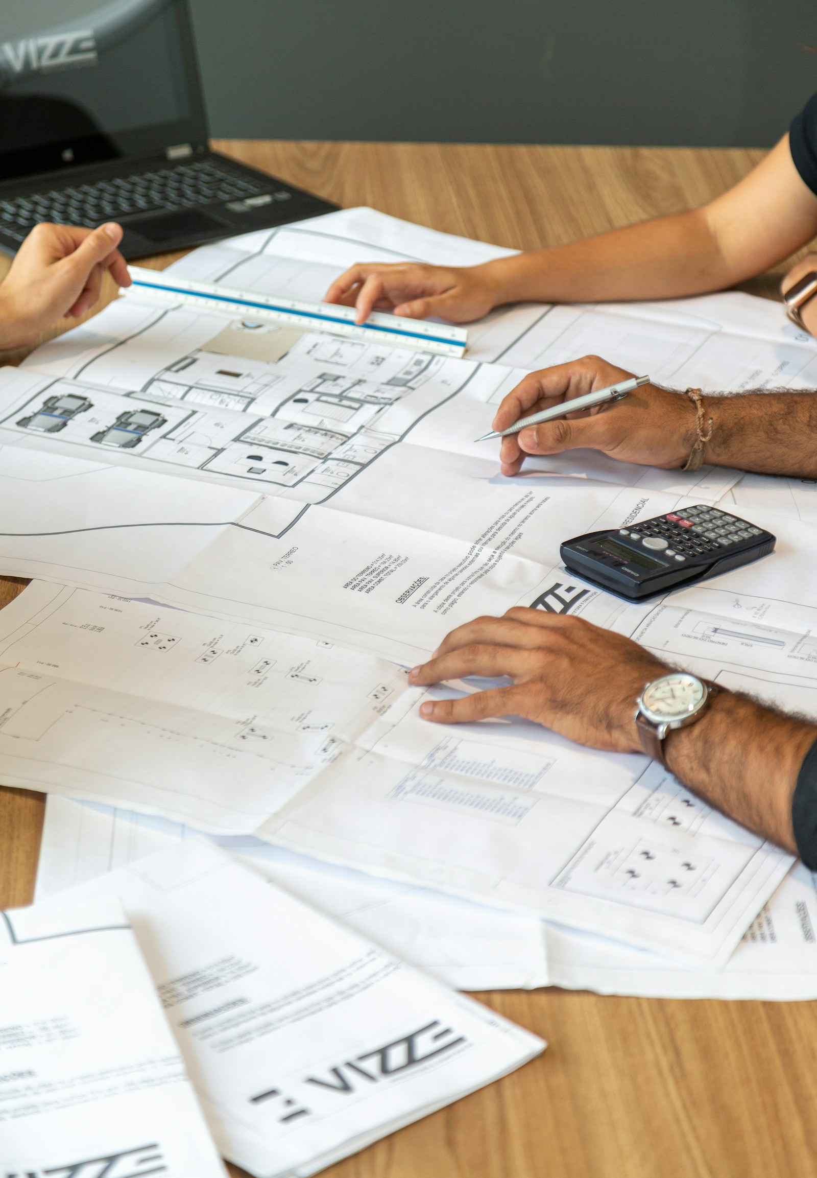Architectural plans being reviewed with a scale ruler and calculator